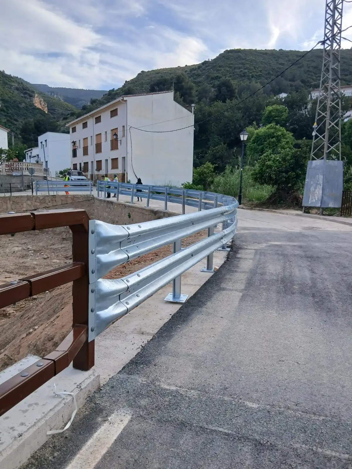 Bionda metálica curva carretera instalación sistema contencion seguridad vial entorno urbano.