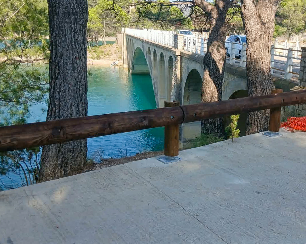Detalle de barrera de seguridad de madera instalada junto a un puente